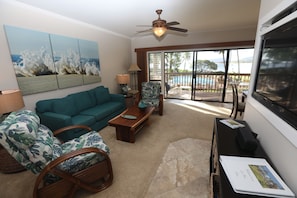 Living Room with view of Lanai, TV and Guest book. Chair on left is a recliner!