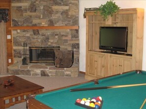 Game room w/ pool table, wet bar, log burning fireplace and 40' TV.