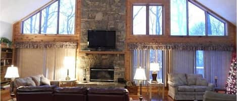 Spacious, sun-filled, great room with log burning fireplace and 54' TV