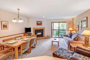 View of open floor plan living room and dining room with gas fireplace and TV