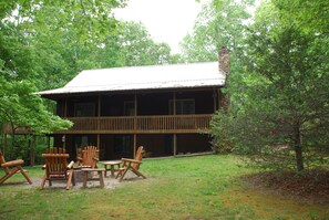 Front of the house, covered porch and fire pit.