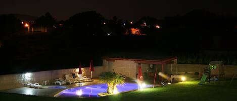 vista nocturna de la zona de piscina.