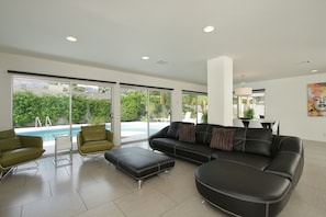 Living area with wall of glass leading to the outdoor pool area