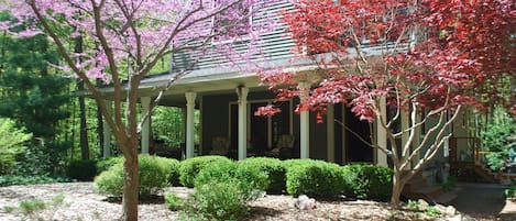 Beautiful wrap around porch nestled in the lush landscaping and woods!
