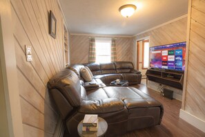 Living room with a nice genius leather sofa and a smart tv. 