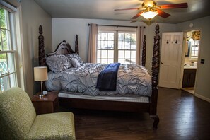 Master bedroom with a king-size bed and access to a half bath. 