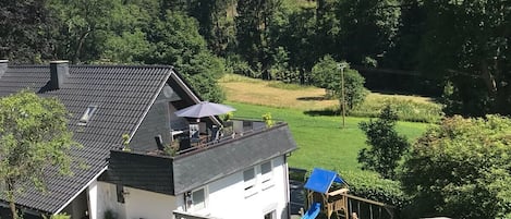 Hausansicht mit Dachterrasse und Garten