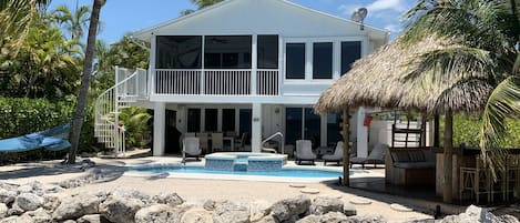 Rear of house from boat dock, private tiki bar, pool, hot tub & beach.