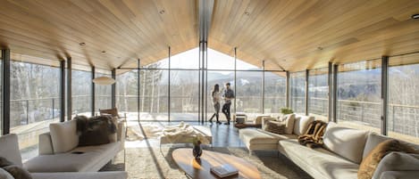 Over-sized living room with glass walls and wraparound decks.