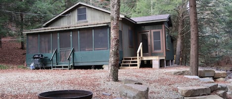 Front view of cabin with fire ring in foreground.