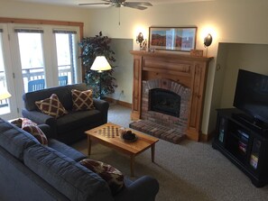 Living area with plenty of light, gas fireplace and 49" flat screen TV