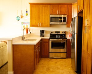 Fully equipped kitchen with quartz countertops and travertine floor