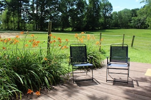 Back porch area with chairs and views of the pastures