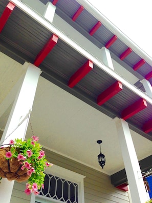 Hopkins House has 2 story front porch with bright red corbels 