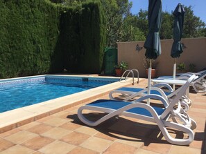 Pool area with 6 sun beds and 2 target umbrellas.
