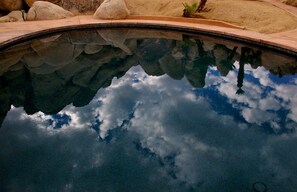 Dark cobalt blue and black bottom of pool reflects the clouds.