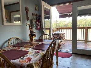 Double French doors leading onto deck. View of lake from dining room table