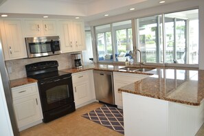 Kitchen with direct access to pool area and pass through window to 2nd family rm