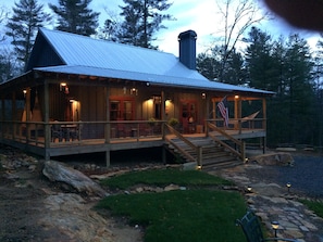 Dusk at Stone-Hinge cabin features
wraparound porch with lighted ceiling fans 