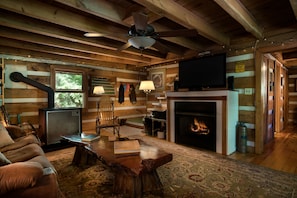 Living room with gas fireplace, wood stove, 50" HDTV, and Bose sound bar