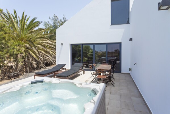 Front main patio with Jacuzzi, sunbeds and dining table