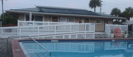 Condo clubhouse with bathrooms, plenty of chairs & tables for relaxing poolside!