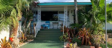 Front entrance to 3-bedroom home showing tropical foliage