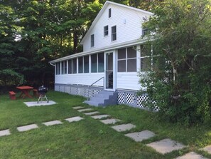 Picnic table and grill below porch