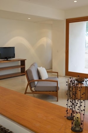 Living area facing the TV with a peek at the patio downstairs facing the ocean