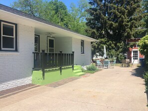 Covered side porch with Adirondack chairs and table