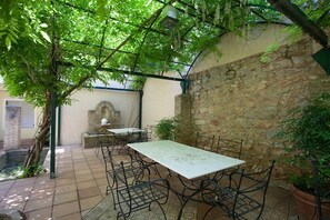 Outdoor dining in garden under wisteria 