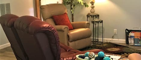 cozy living room with a double recliner loveseat and two single recliners.