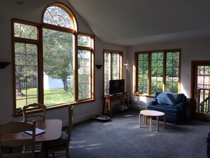 Light filled sunroom with smart TV, comfortable furniture, and dining set
