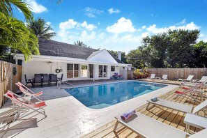 Private pool deck. Lounge chairs and dining table around the heated pool.