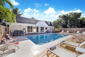 Private pool deck. Lounge chairs and dining table around the heated pool.