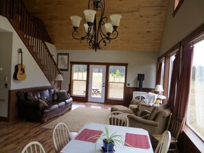 Open floor plan on main level; house guitar; stairs to loft and master bedroom