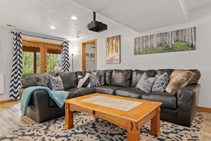 Our den features an extra large sectional & has walk out access to the woods 