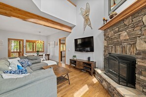 Open concept main level includes a gas fireplace and smart TV with cable