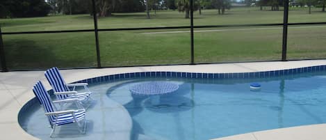 Swim-up bar in swimming pool with golf course view