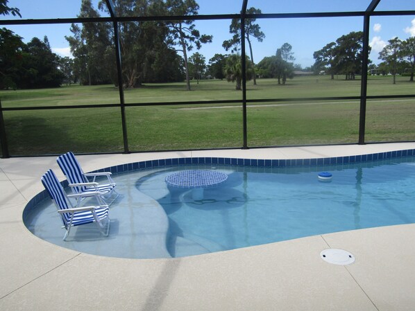 Swim-up bar in swimming pool with golf course view