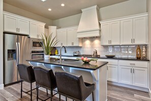 Kitchen View - The Kitchen is fully stocked with all the dishes, cookware, baking pans, and cutlery you will need for meal preparations and includes stainless steel appliances and granite counter tops.