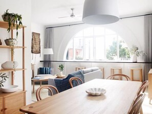 View of sun drenched dining and lounge area with arched window