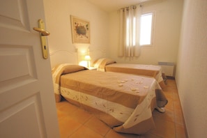 The second bedroom contains two single beds.