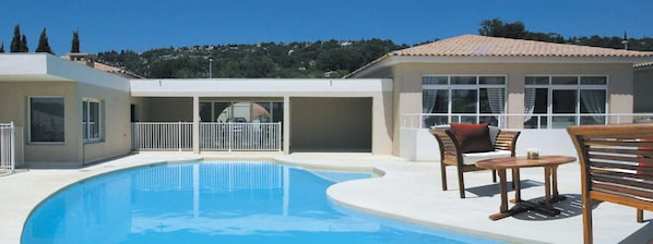 Relax and lounge by the shared outdoor pool.