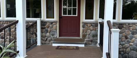 covered porch leading out to pavers, copper fire pit and hot tub. 