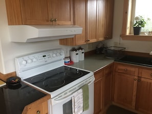 The kitchen is stocked with spices, flour, popcorn and pastas.