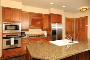 The fully-equipped kitchen features granite countertops and stainless steel appliances