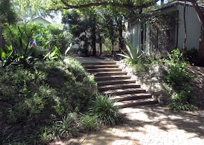 Steps leading from parking area to a brick courtyard.