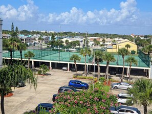 parking lot and tennis/pickleball courts over covered parking.