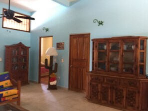 Spacious living room with high ventilation windows and ceiling fans.